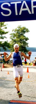 GWL Swim, bike, run Photos by Ed Bailey Peter Putka from Brooklyn, 52, crosses the finish line at 1:30:43 to capture first place among all male competitors.