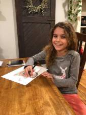Olivia drawing a Christmas mug of hot cocoa. “She is always drawing and looking up things to draw,” her mom, Nicole, told The Warwick Advertiser. “She loves puzzles and being creative.”