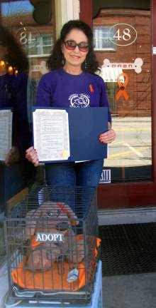 County executive declares April as Prevention of Animal Cruelty Month Photo by Roger Gavan Suzyn Barron, president of the Warwick Valley Humane Society, holding the Orange County proclamation, poses outside Fetch Restaurant, one of the many businesses displaying an orange awareness ribbon.