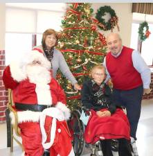 Schervier Pavilion resident Ann Varise joins her daughter Carol Dillon and son-in-law Brian Dillon pose for a photograph with Santa.