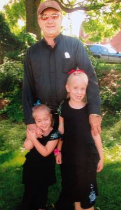 Parish picnics draws 400 The Rev. Joseph Tokarczyk, pastor, with Leah and Holly Purta.