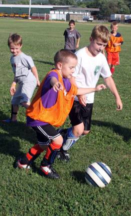 Catching up Daniel Palaj, James Unger and other seven- and eight-year-old boys compete at soccer.