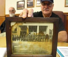 Thom Cronin displays this photo of Warwick firefighters from the early 1900s.