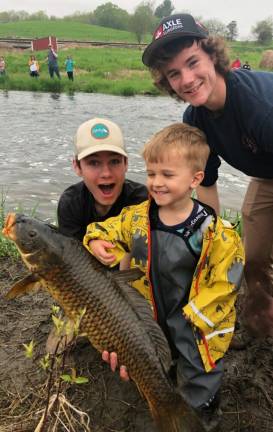 Photo by Bob Nordman Last Saturday was the annual &quot;Take a Kid Fishing&quot; event, sponsored by the Warwick Rod &amp; Gun Club at Wawayanda Creek at the Baird Farm. Volunteers Jake and Rob Burghardt look on as Christian Mack, 4, proudly displays a huge carp that took him five minutes to land. That day he was definitely the smallest kid with the biggest fish. Stories and more photos on page 34.