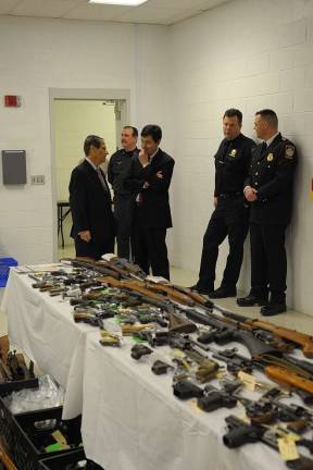Diana's buyback nets 342 guns County Executive Ed Diana and District Attorney Frank Phillips talking before the bevy of firearms on display at the Orange County Sheriff's Office. Many of the long guns exchanged were old and well-worn. (Photo by Joshua Rosenau)