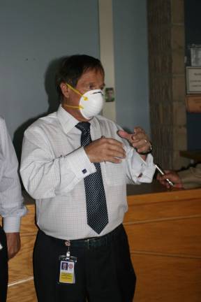 Legislature may investigate government center, Valley View County Executive Diana wears a face mask as he leads reporters on a tour through the closed government center to look at mold and storm damage.