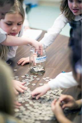How far can a nickel go? St. Stephen first graders Amanda Scott, left, and Ciara Kelly count nickels with their classmates as part of the MaryþÄôs Meals program, which offers a simple solution to world hunger.