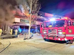 Firefighters work to extinguish the two-alarm fire that shut down parts of Main Street in the Village of Warwick and severely damaged Warwick Valley Auto Body Sunday night.