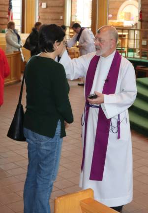 'Turn away from sin and be faithful' Photos by Roger GavanThe Rev. Jack Arlotta, pastor of the Church of St. Stephen, the First Martyr, administers ashes to parishioners on Wednesday, Feb. 14.