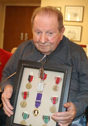 Brothers in war Photo by Roger Gavan World War II Veteran Frank Scharfenberger, 92, proudly wears the “dog tags,” he wore during the invasion of Normandy and the medals and awards he received including the Purple Heart.