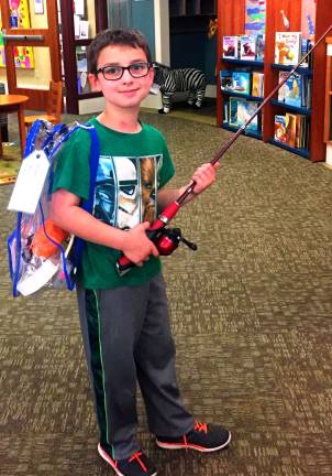 Library introduces Discovery Backpack collection Keene Eicher is seen here modelling the fishing backpack from the Discovery Backpack collection in the Children's Department at Albert Wisner Public Library.