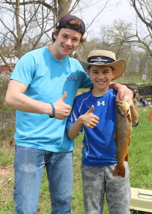Come fish, go fish Volunteer Rob Burghardt (left) was on hand to help young fishermen like Austin Droge, 11, who caught this 18 in. Brown Trout.