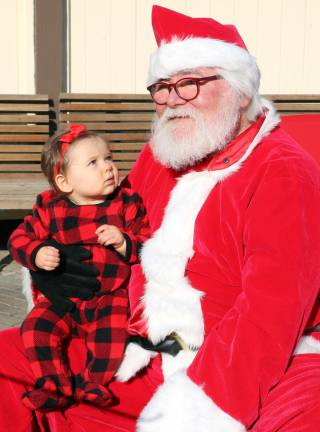 Santa pays his annual early visit to Railroad Green during Home for the Holidays Charlotte Rohllf, all of 10 months, finds Santa very interesting.