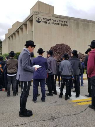 Local teen releases original song in response to synagogue massacre Duvy Burston recites prayers and sings along with his classmates in front of the Tree of Life Synagogue in Pittsburgh (Photo provided)