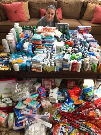 Acts of generosity Warwick Valley High School junior Natalie Daigle is pictured here with donations made by Warwick students and their families for military men and women serving overseas in the armed forces.