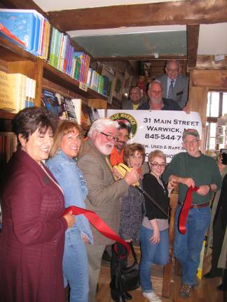 Ye Olde Warwick Book Shoppe celebrates second anniversary Photo by Roger Gavan Front from left, Sherry Bukovcan. President of the Warwick Valley Chamber of Commerce, Vice President Mechelle Casciotta, co-owners Thomas Roberts (cutting ribbon) and Joseph Justin, his mother Lois May, staff member Devynn Ferrero and Town of Warwick Michael Sweeton. Rear, on staircase, from left, Wayne Patterson, Bill Iurato and Doug Stage.