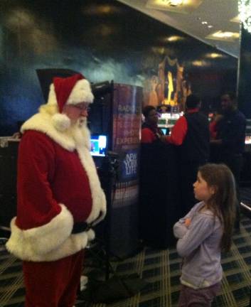 Vote for the best holiday photo Submitted by: Eileen Phillips of Goshen, N.Y. "After visiting Santa at Macy's Herald Square, we took my 9 year old niece to The Radio City Christmas Show. Sophia questioned whether this was the same Santa that she saw earlier, in this picture she's asking him if he remembered what she told him earlier what she wanted for Christmas."