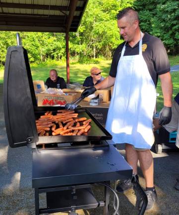 The Warwick Police Department will once again be cooking hot dogs at National Night Out on Aug. 1. Pictured is Det. Mike Hoffman at last year’s event.