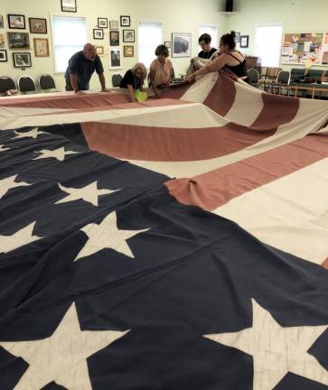 Bryan Ashley, Elena Valentino, Nancy Fernandez, Deanne Singer and Regina Shaw inspect the flag.