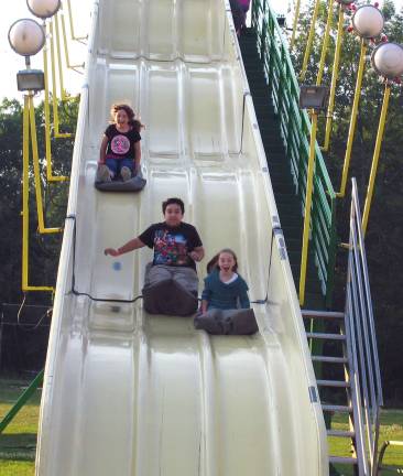 Always the hottest ticket in town Photo by Roger Gavan Racing down the slide: From left, Emily Espinosa, 8, her brother Amin, 12, and their friend Lexie Soller, 9.