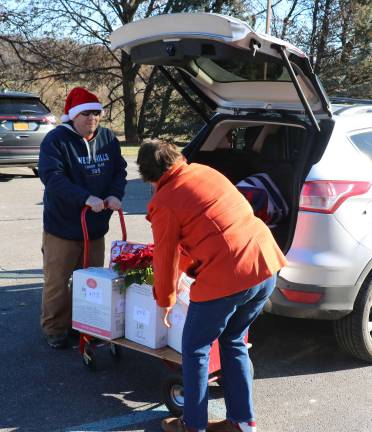 Warwick Ecumenical Food Pantry distributes more than 200 Christmas food baskets Santa's helpers stand by as donors drop off their Christmas baskets.