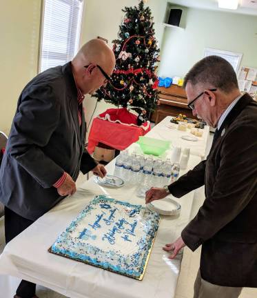 Warwick’s Friendly Visitor Program celebrates its volunteers Vince Copello, Friendly Visitor Program Board chairman, and Warwick Town Supervisor Michael Sweeton cut the holiday cake at the second annual Friendly Visitor Program Volunteer Appreciation/Recognition Holiday Party.