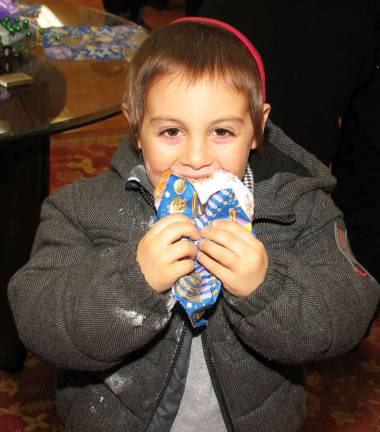 The Warwick Menorah shines anew Photos by Roger Gavan Zushi Borenstein, 5, enjoys a jelly donut.