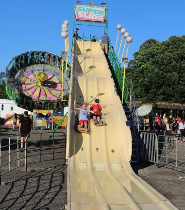 Summertime and the living is easy From left, Dylan Svec, 8, and his friend Harry Piskazlo, 8, enjoy a ride down a huge slide.