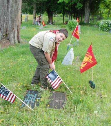 Greenwood Lake remembers and honors Boy Scout Dylan Ried Mueller, 11, places a flag on a veteran's grave in the Greenwood Lake Cemetery.