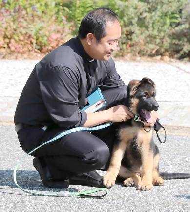 Parochial Vicar Rev. Reynor Santiago demonstrates his own love for dogs.