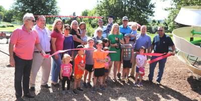 On Friday, Aug. 30, members of the Pine Island and Warwick Chambers of Commerce along with local officials, supporters, families and children, joined members of the Playground Committee to celebrate the grand opening of an updated new playground at Pine Island Park at Kay Road and Treasure Lane. Susan McCosker (center), who spearheaded the project, cuts the ribbon.