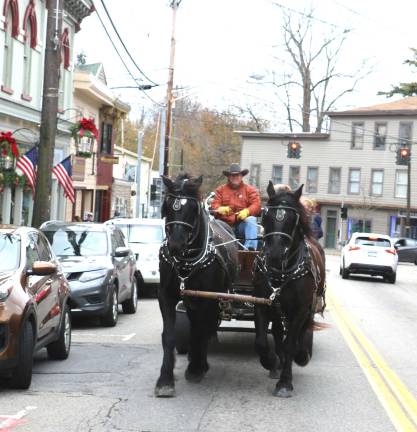 Home for the Holidays launched Sunday, Nov. 19 Sean Giery and his team of Percherons, Jack and Bob, were in the Village again with their mascot “Butch,” who enjoys riding shotgun. And visitors bundled up and took advantage throughout the day of the free horse and buggy rides traveling through the Village.