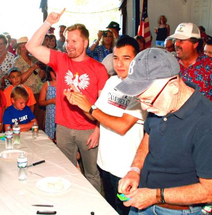 How sweet it is Photos by Ed Bailey Michael Golabek of Chicago, Ill., left, holds up his hand as he wins the onion eating contest. He ate the raw onion in 1 minute 29 seconds as Michael Sweeton, Warwick Town Supervisor, looks down to see how much onion he has left. GolabekþÄôs wife is a doctor in New York City.