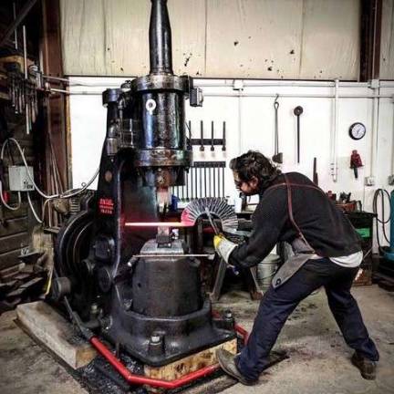 Center for Metal Arts Patrick Quinn, CMA forging studio coordinator, forging parts for a sculpture with a power hammer.