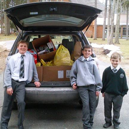 Carry that weight Photos by Chris Bodeker Tyler Kozloski, Eric Bodeker and Alex Bodeker were among students at St. Stephen School who contributed to the success of the schoolís Lenten Food Drive.
