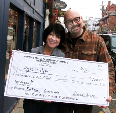 Merchants Guild continues its support for Pink Friday fund raiser Merchants Guild President Mary Beth Schlichting and Pink Friday Chair Tim Mullally with symbolic check for Miles of Hope.