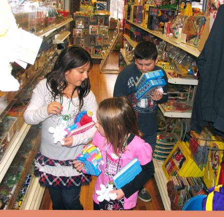 Shopping with the pastor Photo by Roger Gavan The children picked paper doll cutouts describing the gender and size of a child so that they could select proper toys.