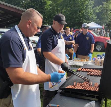 Det. Mike Hoffman and Det. Shawn Tetzlaff cook up hot dogs.