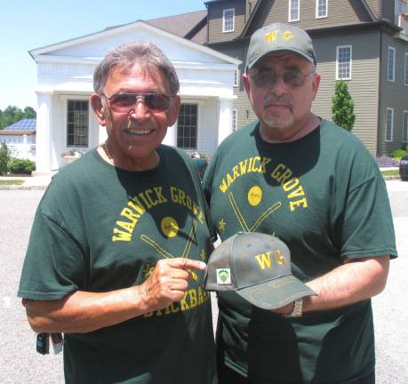 Play (stick)ball Ron Genovese (left) and Dr. Barry Sussner with the signed cap that was presented, along with a Gene No. 1 pin, to Barbara Maloney in memory of her husband.