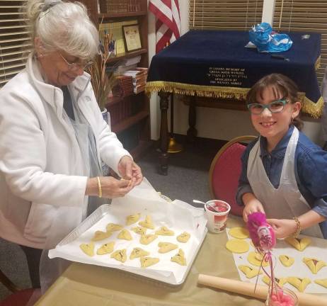 Chabad’s Purim celebration taking us back to the ‘Shetl’ on March 12 Rivkah Burston, 8, shows Samira Galler of Monroe how to shape a Hamantaschen cookie.
