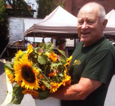 This week at the Warwick Valley Farmers Market Photo provided by Kate Eicher Mark Kurtz of Grammy's Garden shows off some of his sensational sunflowers.