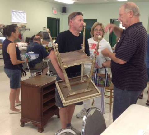 Coach Edwin Winstanley, right, discusses the repair that he made to a vintage table.