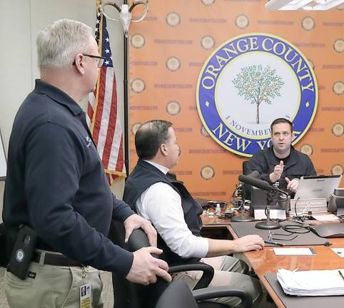 From left to right: Orange County Deputy Commissioner of Police Liaison Services Craig Cherry and Emergency Services Commissioner Brendan Casey speak with County Executive Steven M. Neuhaus in the Emergency Services Center Command Room in Goshen.