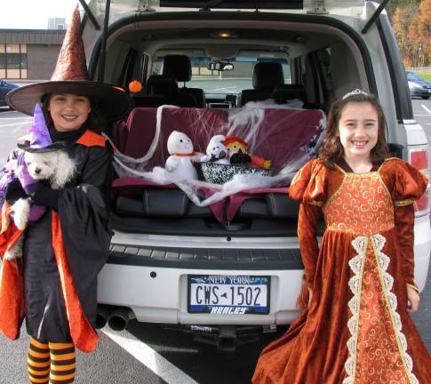 Trunk or Treat this Saturday at noon Last year some automobile trunks were decorated and filled with treats for the children. Posing by their family car from left, "Witch" Amelia Pizza, 11, and her sister Isabella, 9, a princess.