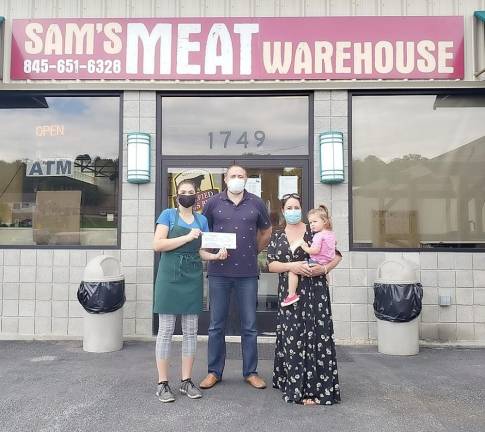 On July 28, Stephen Kitar, owner of Sam’s Meat Warehouse in the Village of Florida, presented a check for $2,000 to Carmela Borrazas, founder of Hugs for Courage. From left, Uliana Kitar, her father, Stephen Kitar, and Carmela Borrazas, cofounder of Hugs for Courage, with her daughter Penelope. Photo by Terry Gavan.
