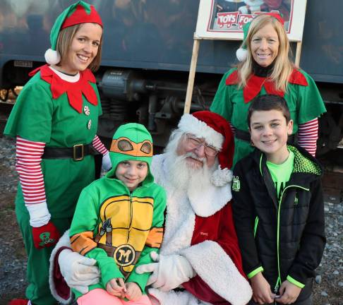 It is starting to feel like Christmas Santa spent almost an hour outside posing for photographs with children and families. Seated with Santa from left are Angelica Koleser, 7 and her brother Anthony, 10. Elves in rear from left, Michelle Donovan and Susan Hembury. Anthony asked Santa for an i phone 7 and his sister Angelica requested Pokemon items.