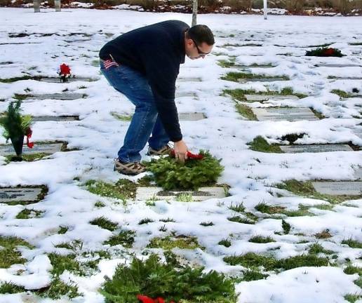 Orange County Executive Steven M. Neuhaus puts a wreath down during the ceremony.