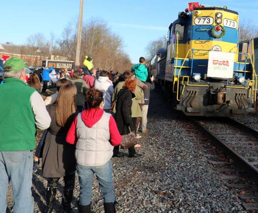 Photos by Roger Gavan On Sunday afternoon, December 4, Christmas was still four weeks away. But by 3 p.m. a large crowd had gathered in the Chase Bank parking lot as Middletown &amp; New Jersey Railroad Engineer Paul Hintz, sounding a loud whistle, drove a diesel locomotive pulling a train of railroad freight cars along with passenger compartments and an observation car into the Village of Warwick.