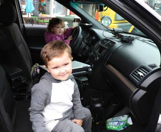 Sophie Burns, 2, and her brother Liam, 3, had an opportunity to play cops and robbers by sitting behind the wheel and special equipment in a real patrol car.
