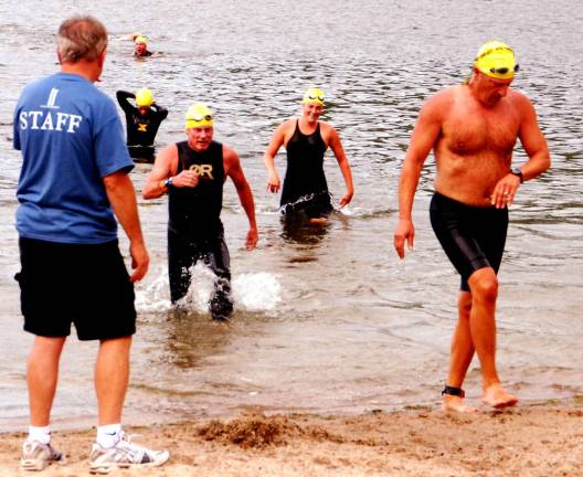 GWL Swim, bike, run The triathletes emerge from Greenwood Lake after finishing the swim portion of the race. From here, they moved onto their bicycles for the second leg of race.